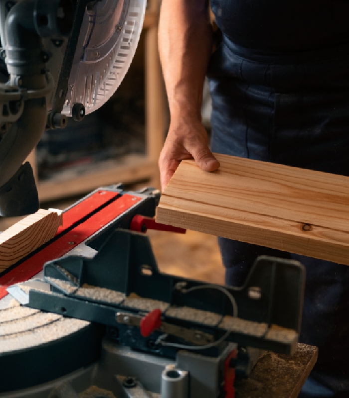 Découpe de bois en atelier de menuiserie pour la création d’une fenêtre