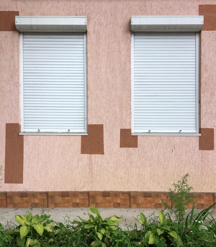 Volets roulants blancs fermés sur les fenêtres d’une maison