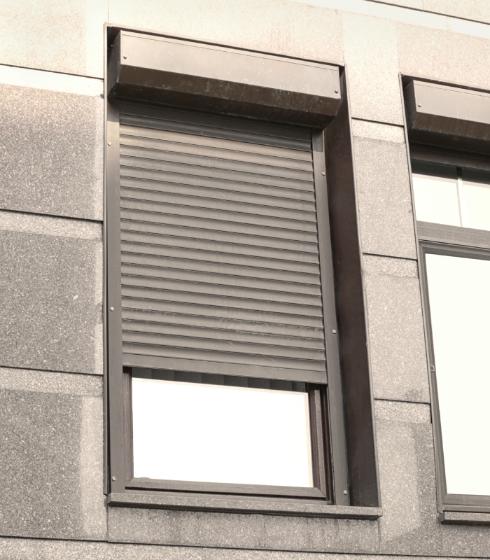 Volet roulant gris installé sur une fenêtre de façade moderne